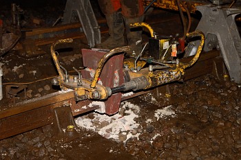 A hydraulic cutter is clamped to the rail